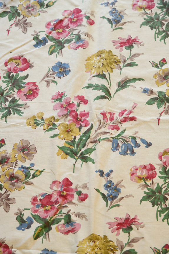 Vintage floral chintz fabric featuring colourful botanical print on a soft cream background