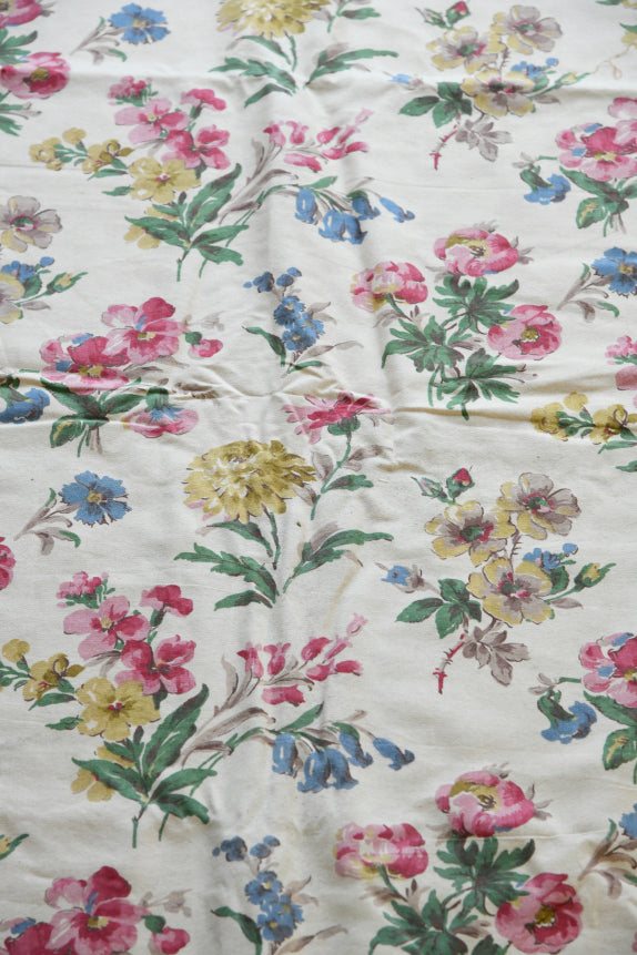 Angled view of vintage chintz material displaying repeated floral arrangement and texture