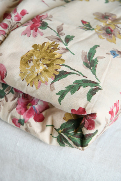 Folded edge detail of vintage fabric showing drape and printed floral surface